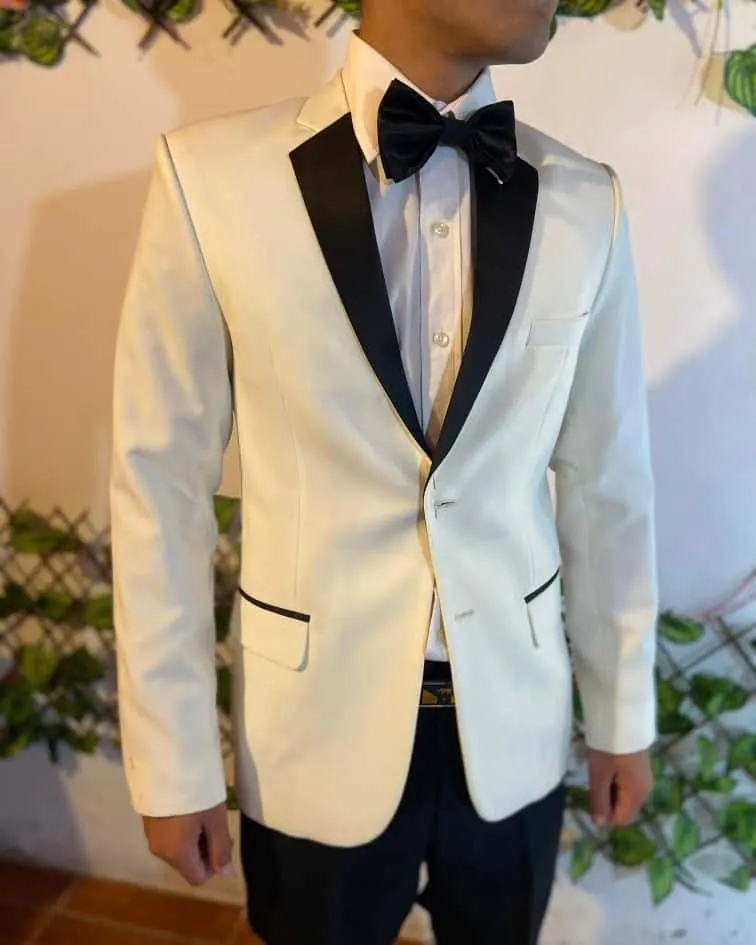 Joven con saco blanco de solapa negra y moño