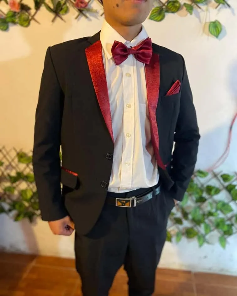 Joven con saco negro de solapa roja y moño rojo