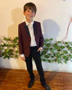 Niño con saco bordó, camisa blanca y moño