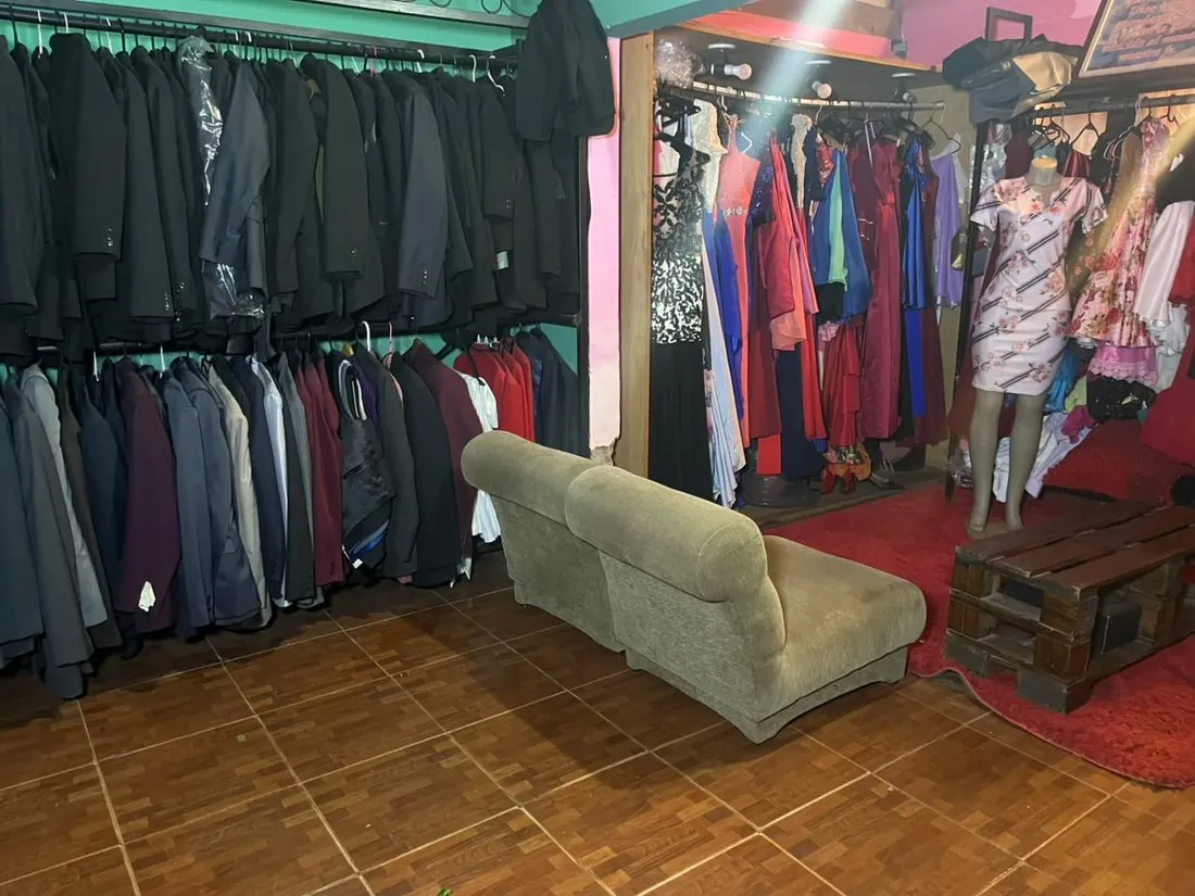 Sala de pruebas del taller, con trajes colgados y un sillón